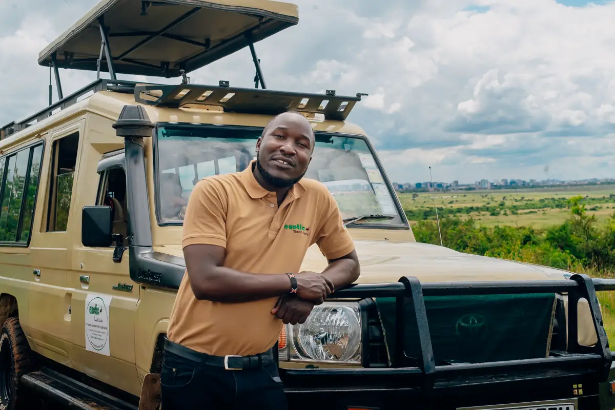 Exotic Travel Centre safari guide beside a safari vehicle